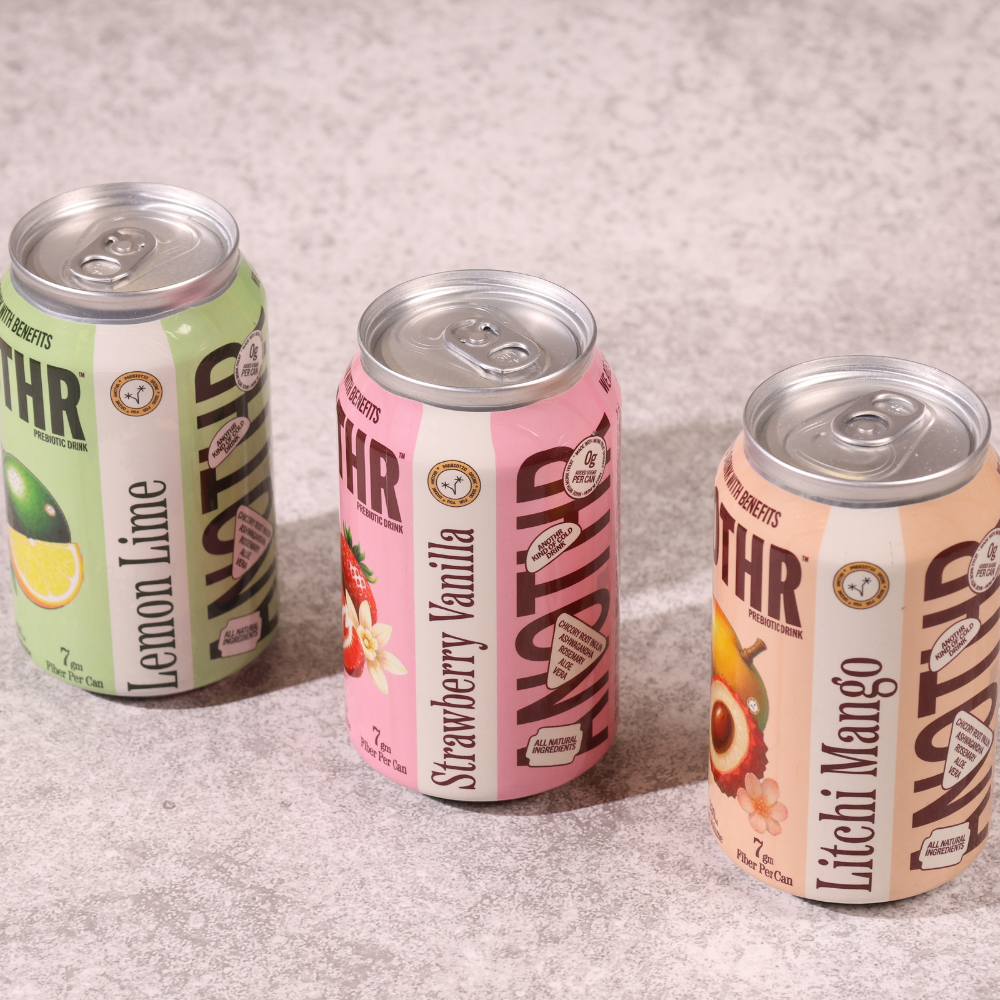 Three cans of a beverage brand on a textured surface. Anothr plant-based fiber drink served chilled on a summer afternoon