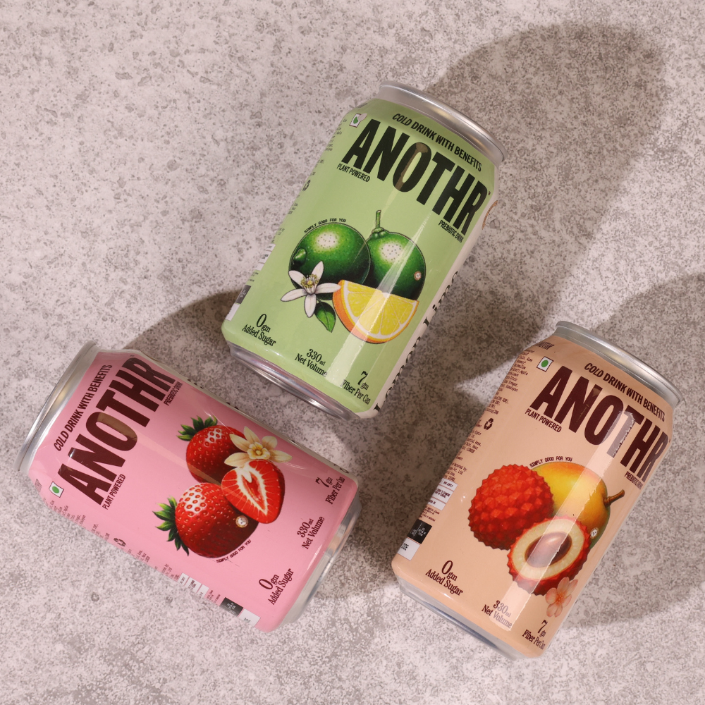 Three cans of 'ANOTHR' with different fruit-themed designs on a textured surface. A better for you healthy cold drink brand
