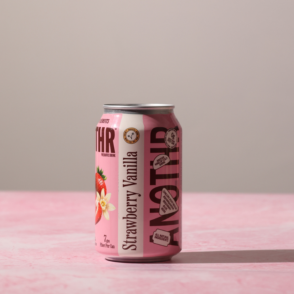 Pink can of Strawberry Vanilla a prebiotic colddrink made in india on a pink surface with a gray background