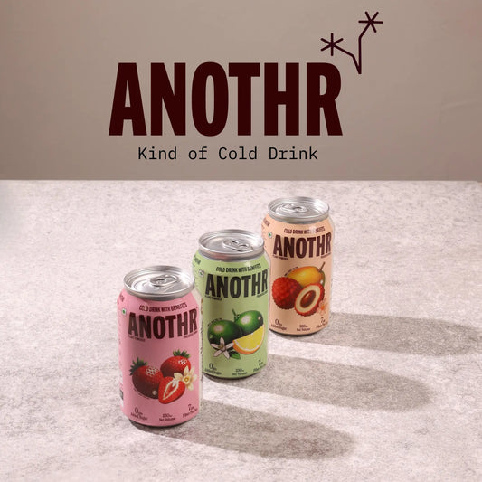 Three cans of a beverage brand called ANOTHR Prebiotic Cold Drink on a textured surface. Anothr plant-based fiber drink served chilled on a summer afternoon