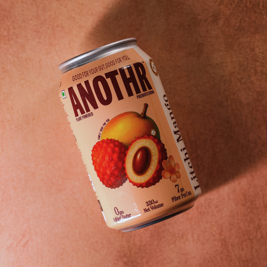 Can of 'ANOTHR'  Mango Litchi plant-powered beverage supporting gut microbiome health on a brown background